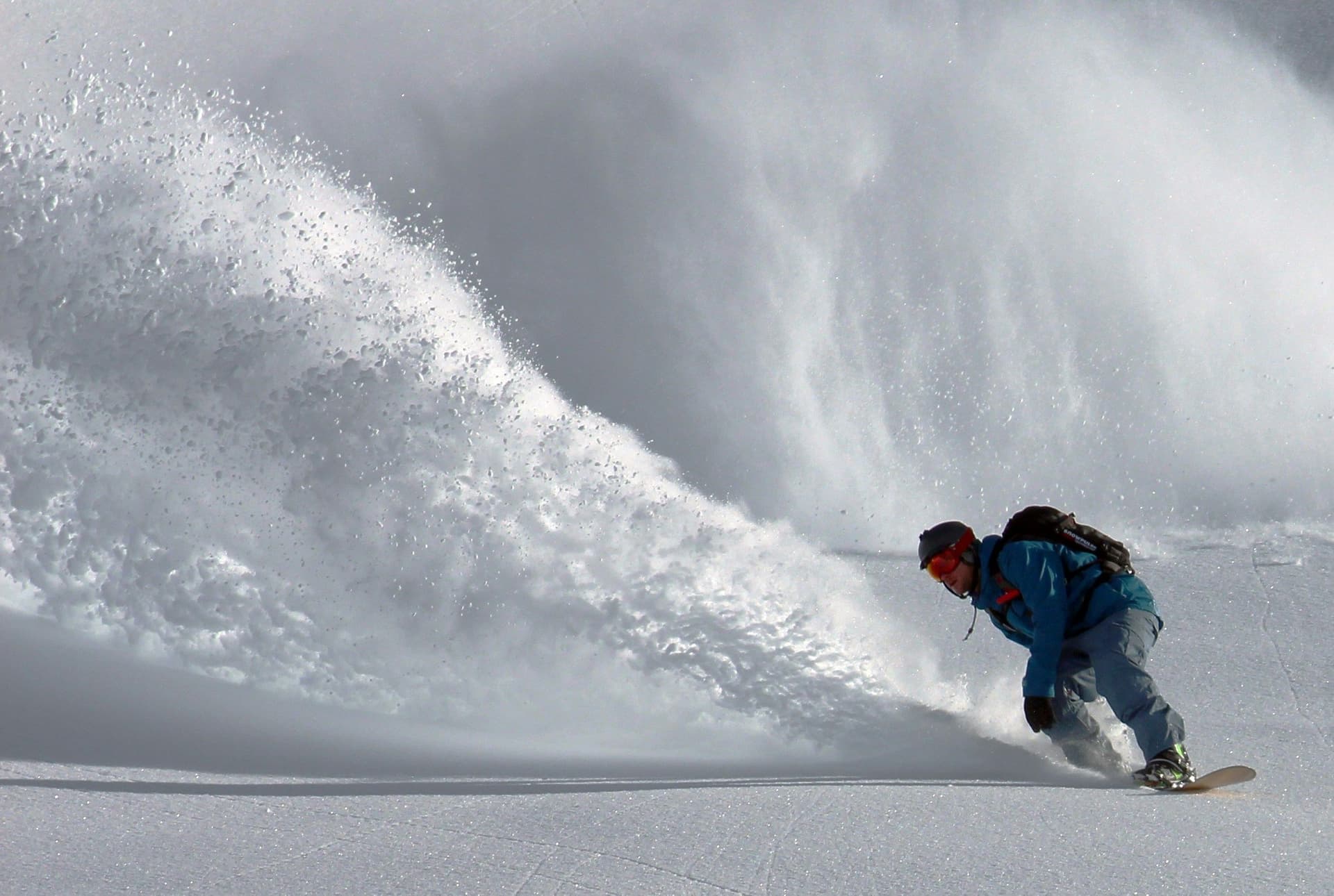 Snowboarder in front of an avalanche
