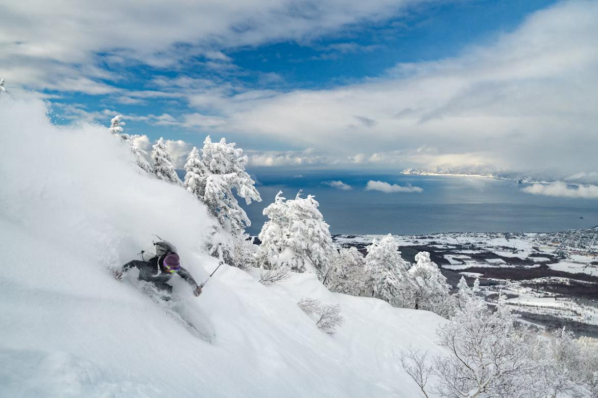 Skier enjoying the japow with Sea of Japan in the background