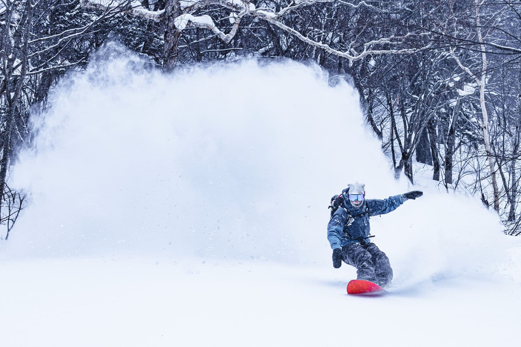 Snowboarder enjoying backcountry pow in Aomori